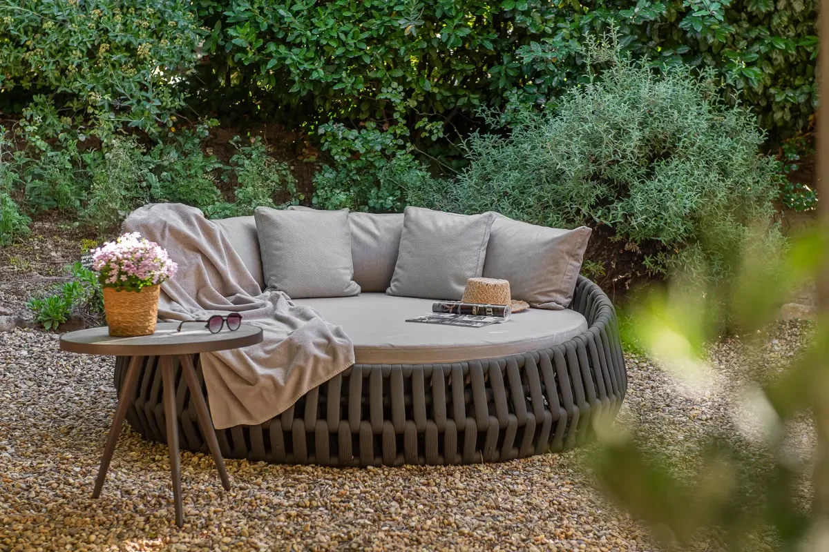 Canapé extérieur cosy dans jardin verdoyant