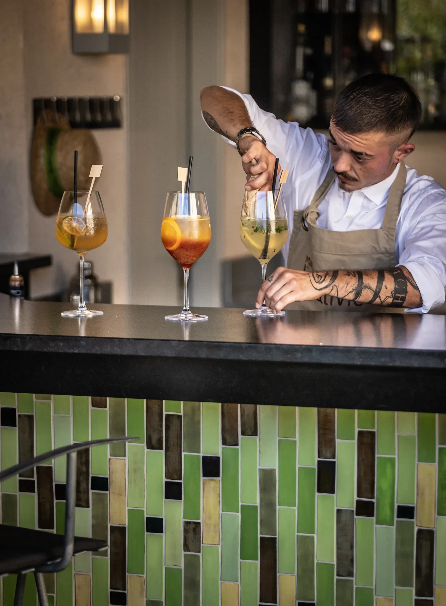 Barman préparant des cocktails colorés au comptoir