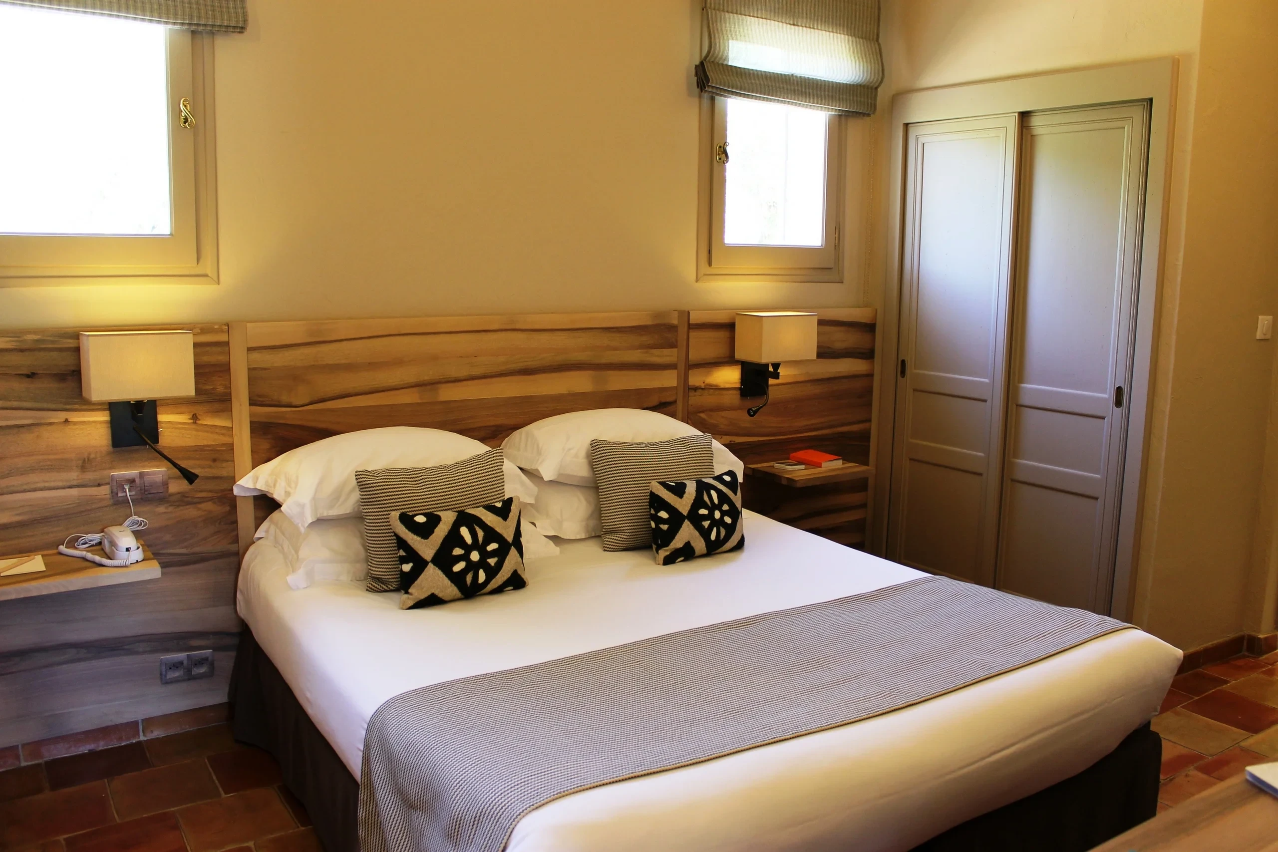 Chambre avec lit double et tête de lit en bois