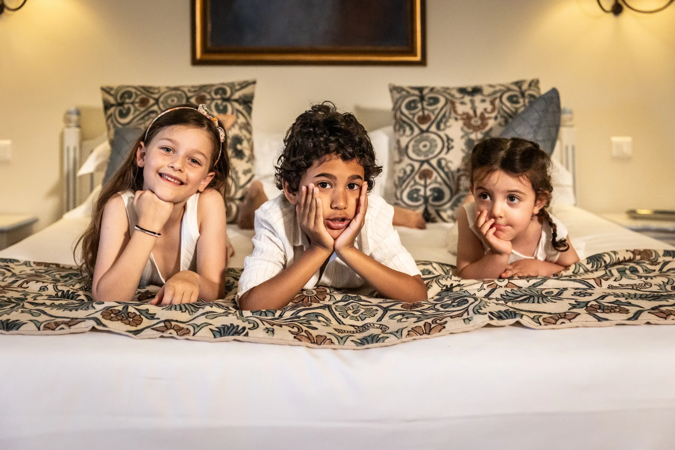Trois enfants allongés sur un lit