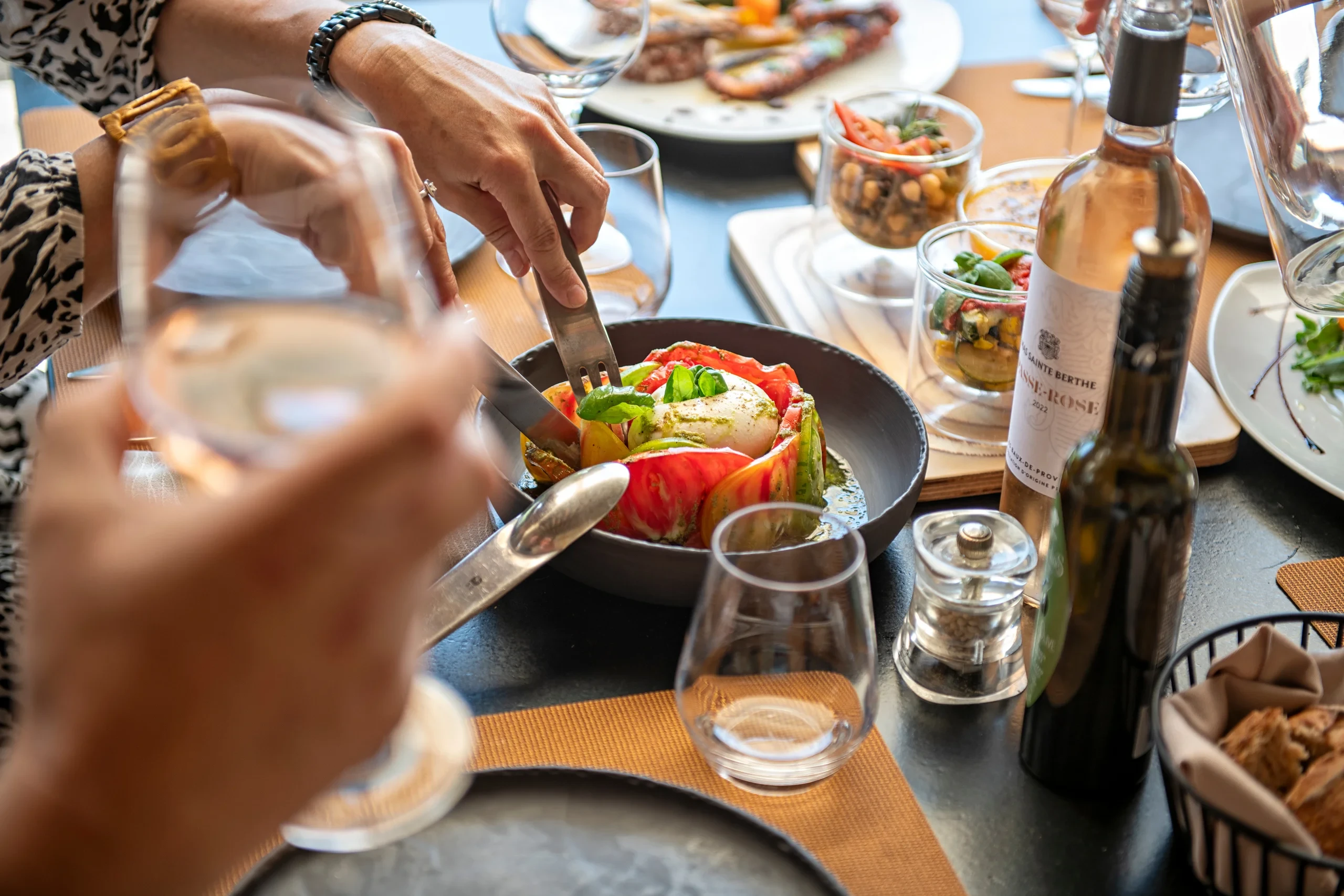 Repas convivial avec plat coloré et vin rosé
