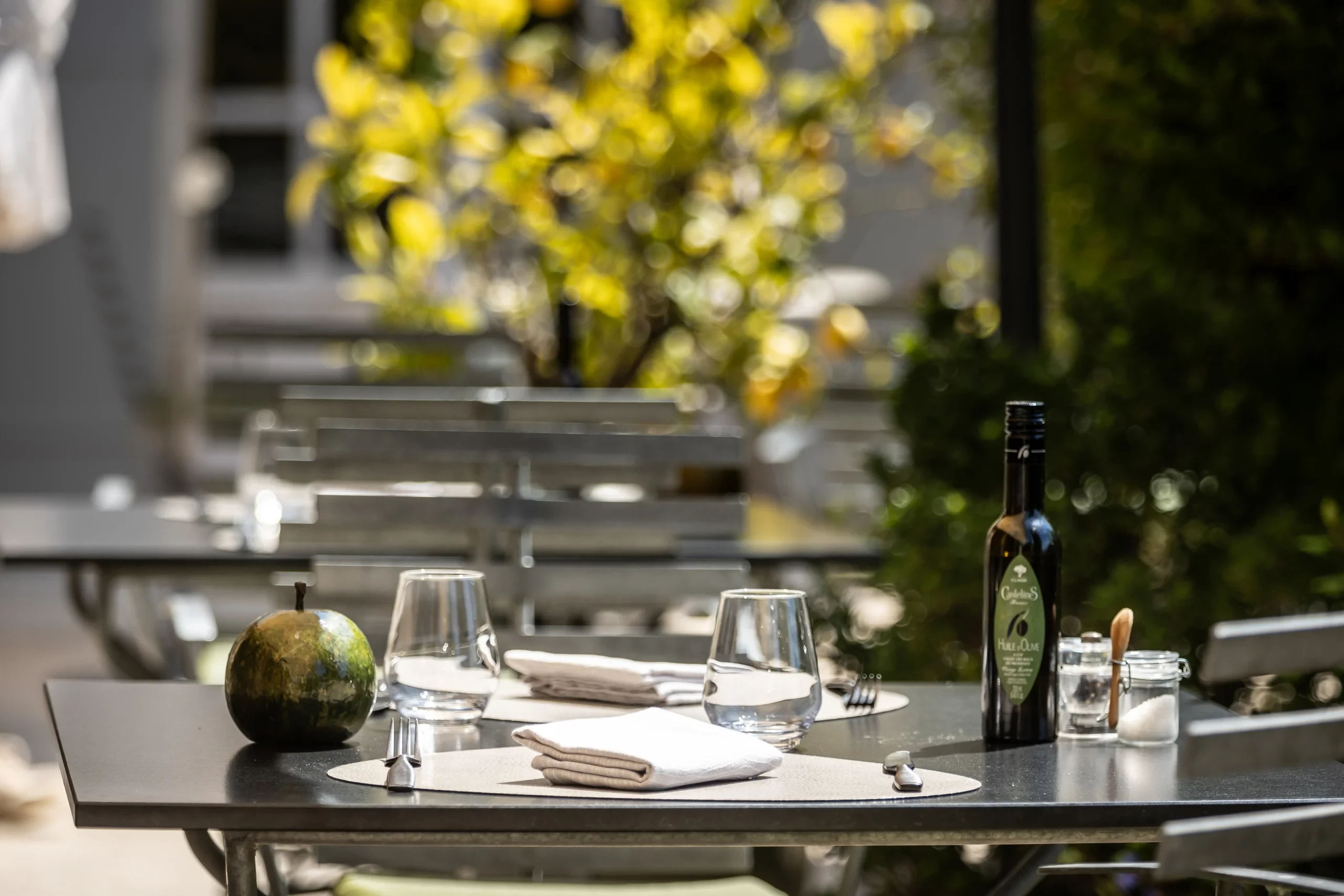 Table d'extérieur avec bouteille d'huile d'olive et verres