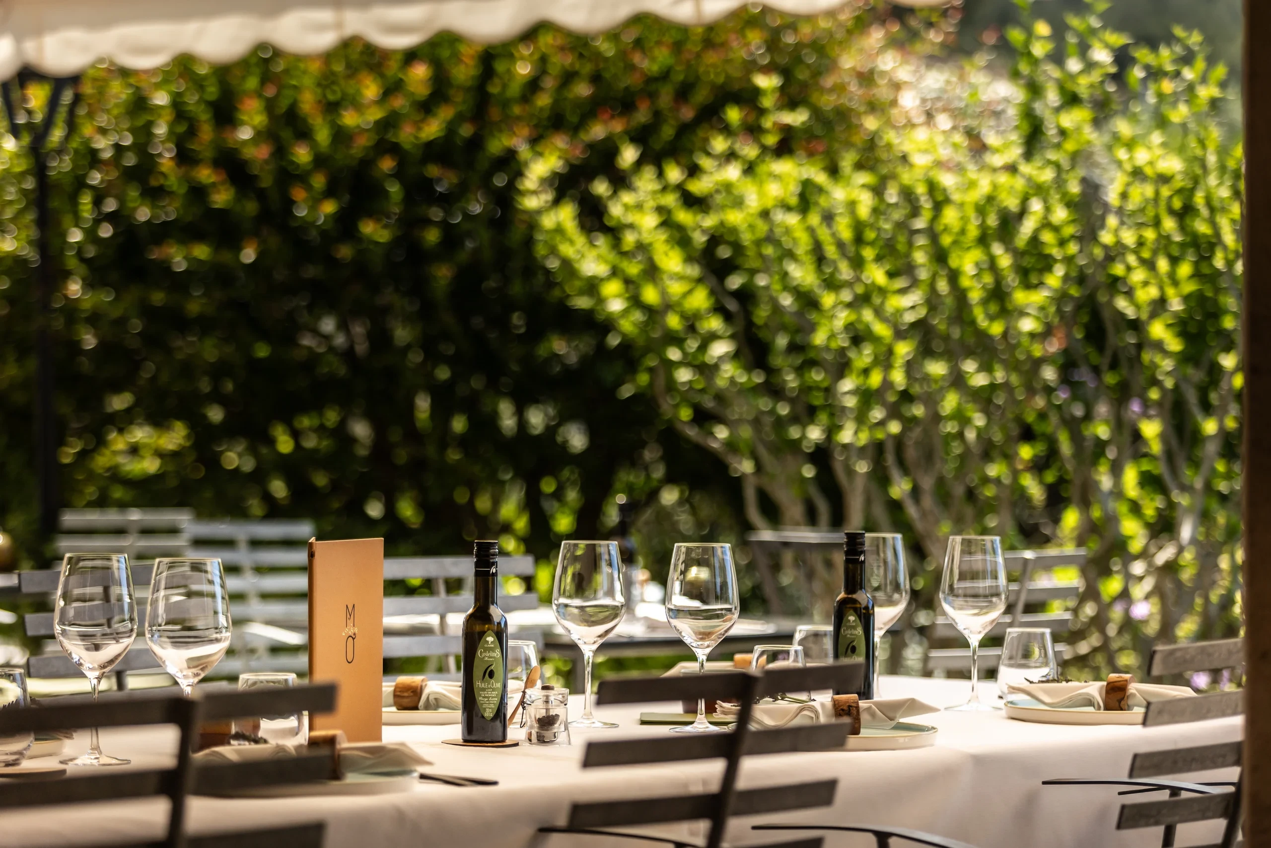 Table dressée en terrasse avec verres et bouteilles - hotel de charme alpilles - Mas de l'Oulivié