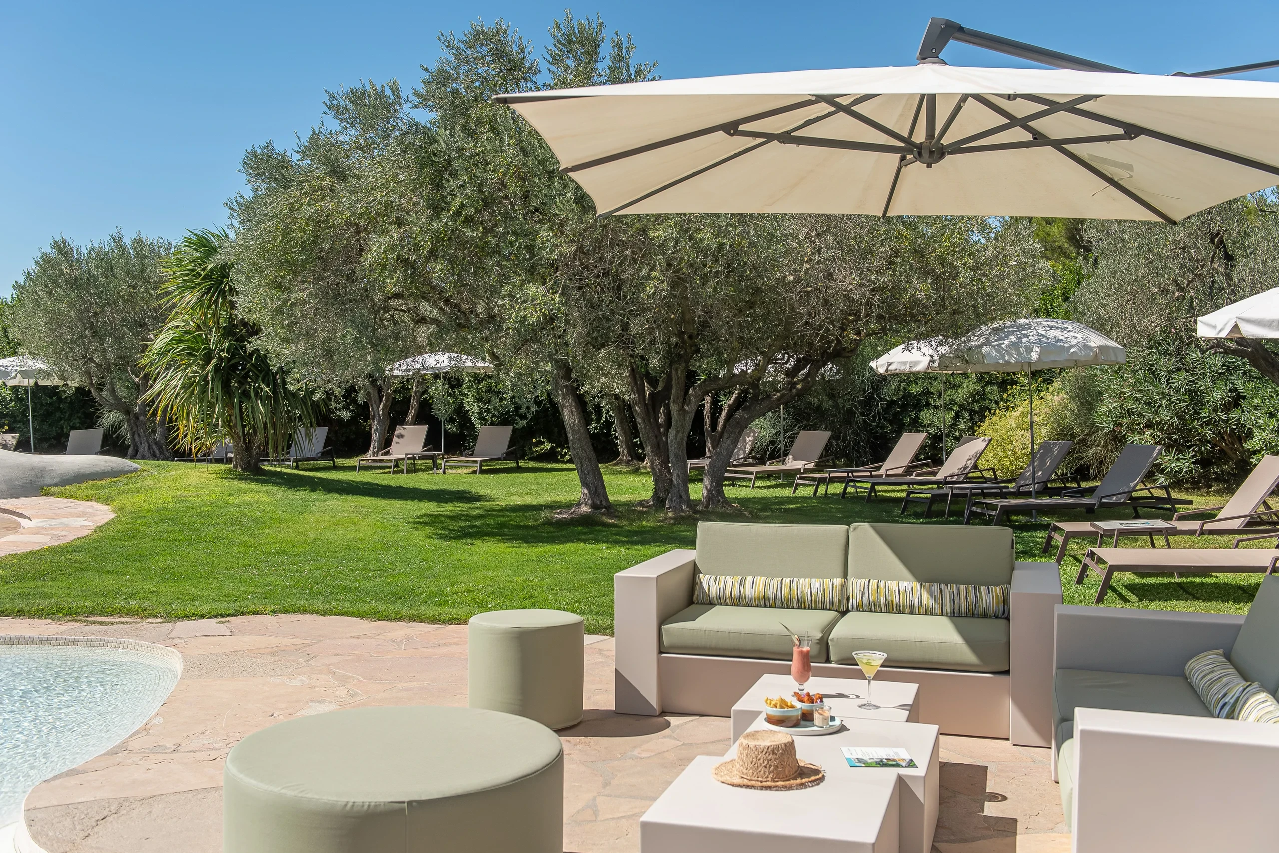 Jardin avec transats et piscine lors d'une journée ensoleillée - hotel de charme alpilles - Mas de l'Oulivié